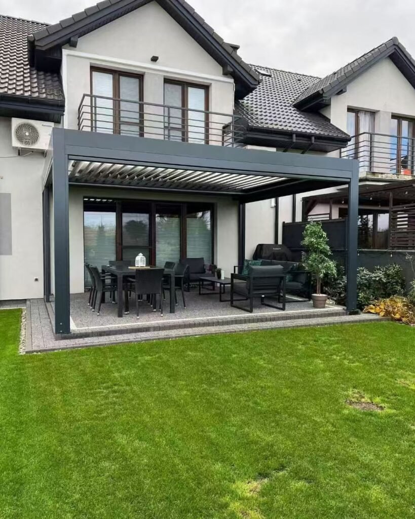 Motorized aluminum louvered pergola with adjustable roof blades installed over a residential garden patio