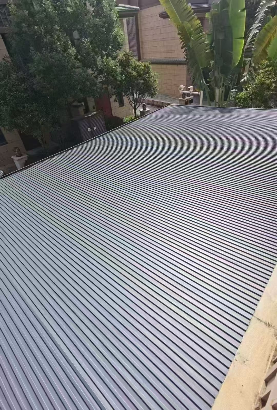 Close-up of a closed aluminum louvered pergola roof providing sunshade and rain protection for a residential outdoor area