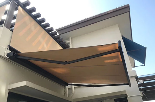 Brown wall-mounted retractable folding arm awning extended above a residential balcony