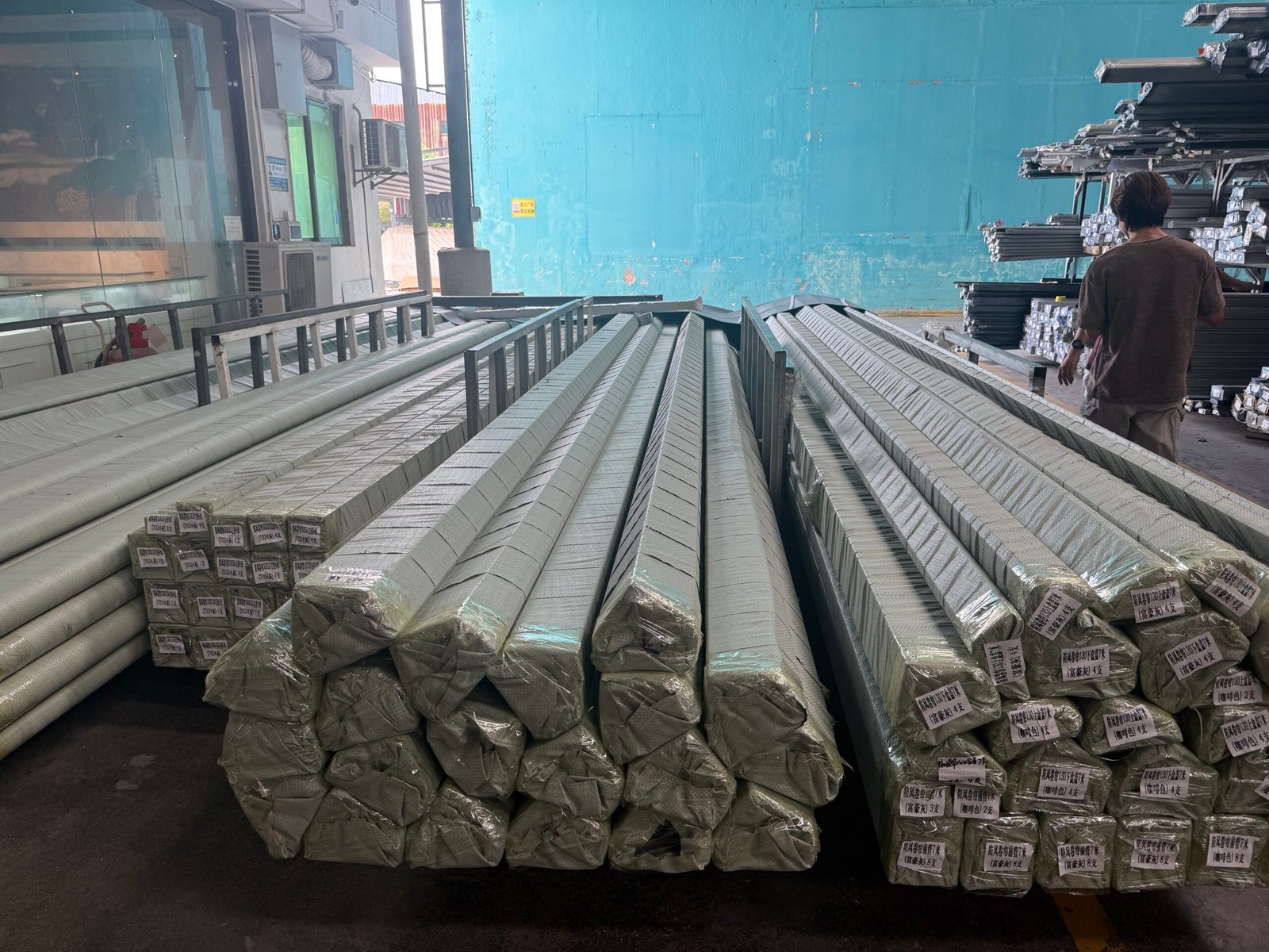Wrapped and labeled aluminum profiles organized by order in the factory