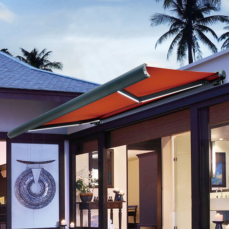 Wall-mounted full-cassette retractable awning with orange fabric, aluminum folding arms and integrated LED lighting