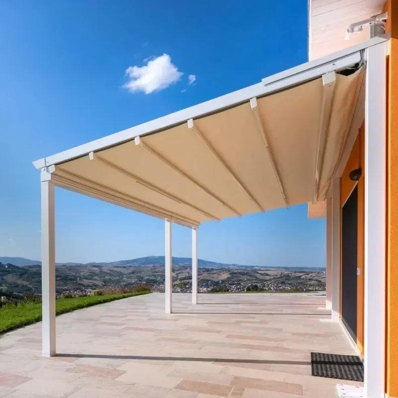 White motorized retractable pergola awning with an aluminum frame and fabric canopy installed over a residential terrace