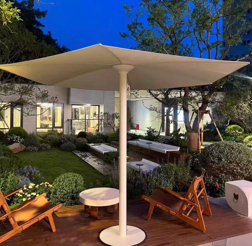 Large square center-pole patio umbrella providing shade over an outdoor garden seating area